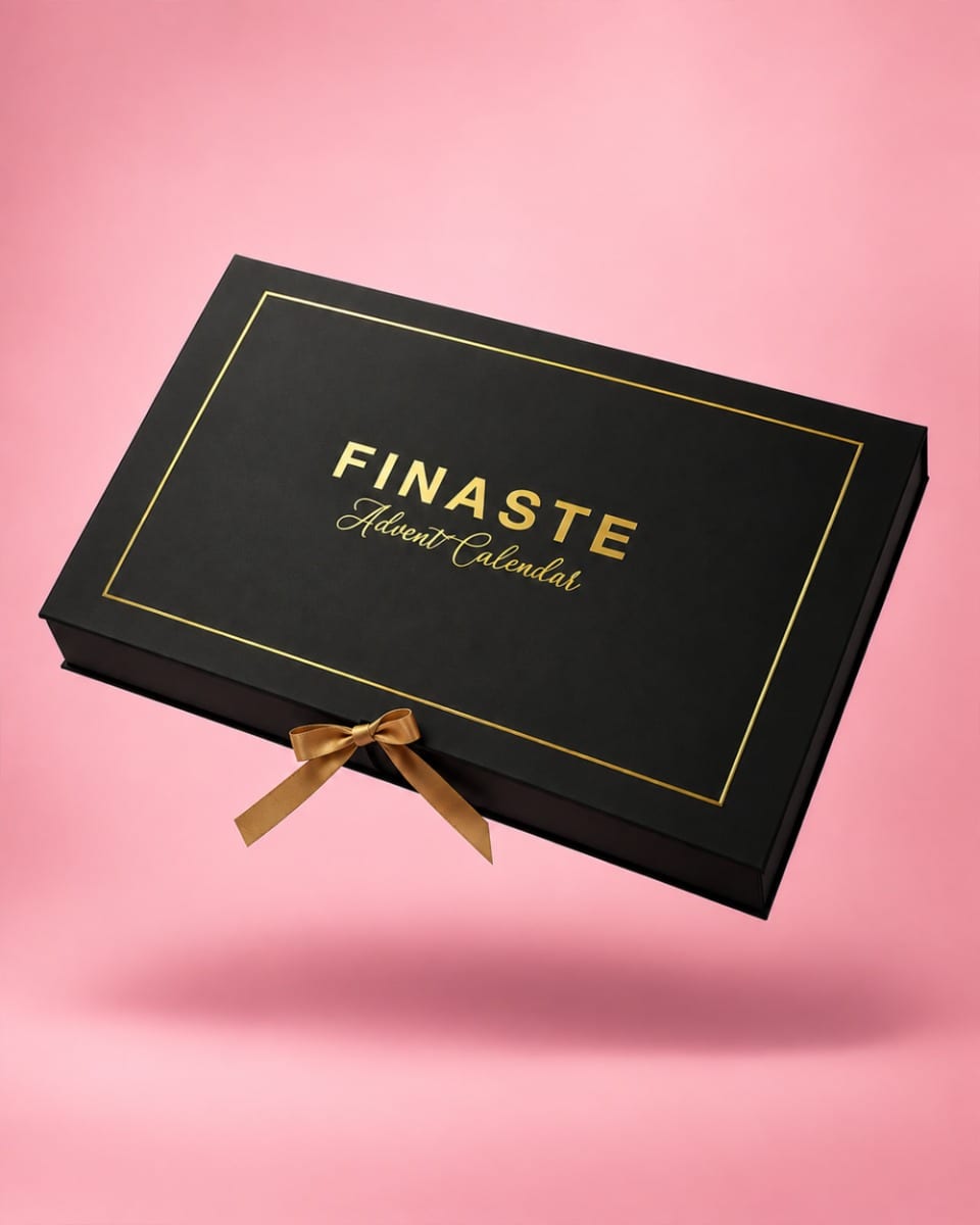 Zwarte FINASTE adventskalender 2026 met gouden letters en een gouden strik