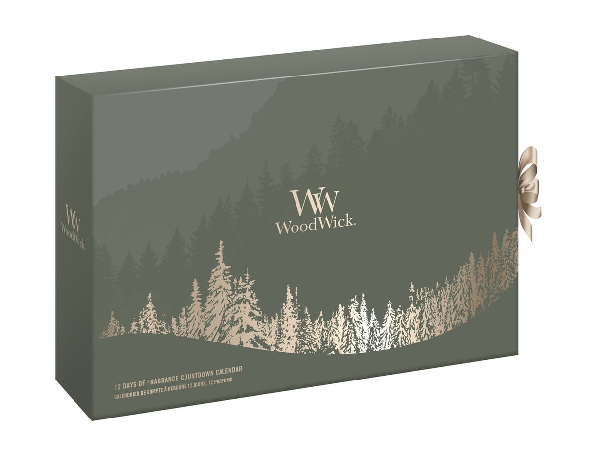 Groene WoodWick 12 Days of Fragrance adventskalender 2026 met een dennenbos in goud en een satijnen strik